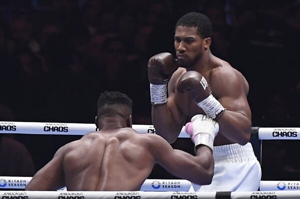 British former world champion Anthony Joshua, right, and MMA fighter Francis Ngannou fight during the heavyweight boxing showdown at Kingdom Arena in Riyadh, Saudi Arabia, Saturday, March 9, 2024. (AP Photo)