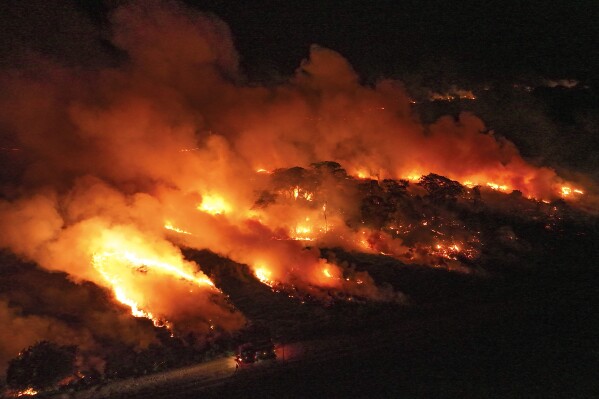 A wildfire consumes an area next to the Transpantaneira road in the Pantanal wetlands near Pocone, Mato Grosso state, Brazil, Nov. 15, 2023. (AP Photo/Andre Penner, File)