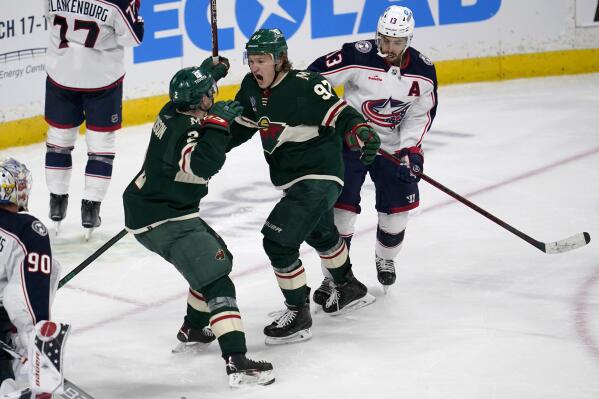Minnesota Wild left wing Kirill Kaprizov, middle, celebrates with defenseman Calen Addison, left, after scoring the game-winning goal to defeat the Columbus Blue Jackets during overtime of an NHL hockey game Sunday, Feb. 26, 2023, in St. Paul, Minn. (AP Photo/Abbie Parr)