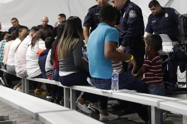 FILE - In this Sept. 17, 2019, file photo, migrants who are applying for asylum in the United States go through a processing area at a new tent courtroom at the Migration Protection Protocols Immigration Hearing Facility, in Laredo, Texas. In the latest twist for a signature Trump administration immigration policy, a federal appeals court said it is halting a policy next week to make asylum-seekers wait in Mexico for court hearings in the United States. But the U.S. 9th Circuit Court of Appeals in San Francisco said Wednesday, March 4, 2020, that it would only block the "Remain in Mexico" policy in Arizona and California, the two border states where its authority extends. (AP Photo/Eric Gay, File)