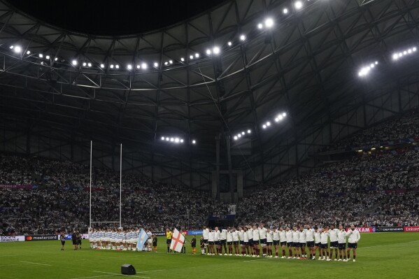 The two teams line up for the national anthem just prior to kick off, England are right, at the Rugby World Cup Pool D match between England and Argentina in the Stade de Marseille, Marseille, France Saturday, Sept. 9, 2023. (AP Photo/Pavel Golovkin)