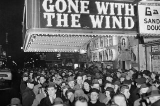 FILE - In this Dec. 19, 1939 file photo, a crowd gathers outside the Astor Theater on Broadway during the premiere of "Gone With the Wind" in New York. HBO Max has temporarily removed “Gone With the Wind” from its streaming library in order to add historical context to the 1939 film long criticized for romanticizing slavery and the Civil War-era South. (AP Photo)