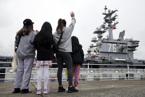Family members of the crew of the U.S. navy aircraft carriers USS Ronald Reagan (CVN-76) see off at the U.S. navy's Yokosuka base Thursday, May 16, 2024, in Yokosuka, south of Tokyo. This is the ship's final departure from Yokosuka before transiting back to the United States. (AP Photo/Eugene Hoshiko)