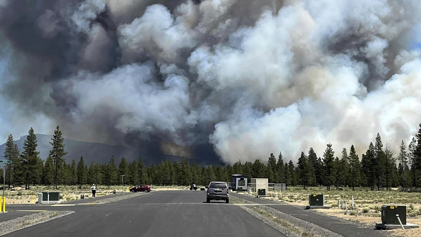 Gusty winds help spread fast growing central Oregon wildfire and prompt evacuations