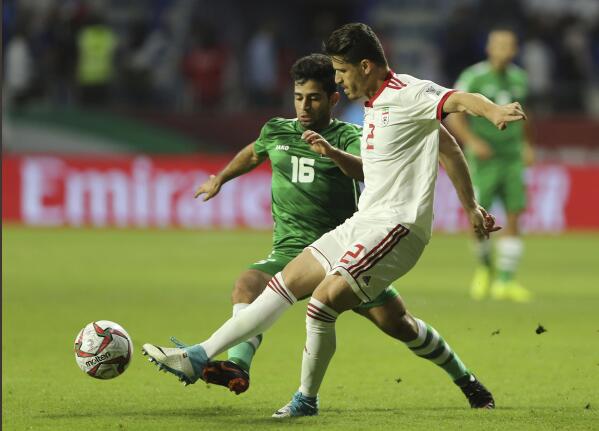 FILE— Voria Ghafouri, then an Iranian national soccer team player, right, fights for the ball with Iraqi midfielder Hussein Ali, during the AFC Asian Cup soccer match at the Al Maktoum Stadium in Dubai, United Arab Emirates, Jan. 16, 2019. The semiofficial Fars and Tasnim news agencies reported on Thursday, Nov. 24, 2022, that Iran arrested Ghafouri, a prominent former member of its national soccer team for insulting the national soccer team, which is currently playing in the World Cup, and criticizing the government as authorities grapple with nationwide protests. (AP Photo/Kamran Jebreili, File)