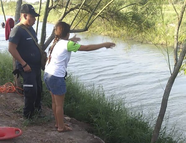 In this Sunday, June 23, 2019 photo, Tania Vanessa Ávalos of El Salvador speaks with Mexican authorities after her husband and nearly two-year-old daughter were swept away by the current in Matamoros, Mexico, while trying to cross the Rio Grande to Brownsville, Texas. Their bodies, the toddler still tucked into her father's shirt with her arm loosely draped around him, were discovered Monday morning several hundred yards from where they had tried to cross. (AP Photo/Julia Le Duc)