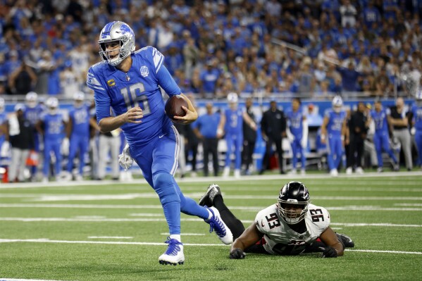 Detroit Lions quarterback Jared Goff (16) gets past Atlanta Falcons defensive tackle Calais Campbell (93) as Goff scores a touchdown in the second half of an NFL football game Sunday, Sept. 24, 2023, in Detroit. (AP Photo/Al Goldis)