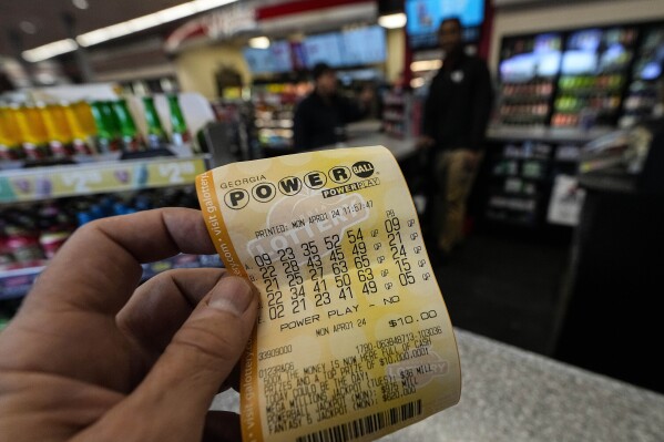 FILE - A Powerball lottery ticket is seen inside a convenience store, Monday, April 1, 2024, in Kennesaw, Ga. Powerball will match a record for lottery losing Saturday night, April 6, with a stretch of more than three months without a jackpot winner. (AP Photo/Mike Stewart, FIle)