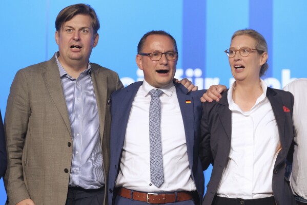 From left, Maximilian Krah, the 'Alternative fuer Deutschland' (Alternative for Germany) party top candidate for the European elections, Tino Chrupalla, co-chairman of the AfD and Alice Weidel, co-chairwoman of the AfD, sing the national anthem at the end of the European election meeting in Magdeburg, Germany, Sunday, Aug. 6, 2023. The 10-year-old Alternative for Germany, or AfD, gathered in the eastern city of Magdeburg for a convention stretching over two weekends at which it plans to choose candidates and set its policy platform for next June's European Parliament election. (Klaus-Dietmar Gabbert/dpa via AP)