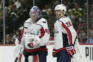 Washington Capitals goaltender Darcy Kuemper (35) and right wing Nic Dowd (26) stand in the goal during the third period of an NHL hockey game against the Minnesota Wild, Tuesday, Jan. 23, 2024, in St. Paul, Minn. (AP Photo/Abbie Parr)