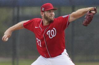 FILE - Washington Nationals pitcher Stephen Strasburg throws live batting practice in a drizzle during the team's spring training baseball workout March 15, 2022, in West Palm Beach, Fla. Strasburg is scheduled to make his season debut against the Miami Marlins on Thursday. The 33-year-old Strasburg has been sidelined for most of the past two seasons. He underwent surgery for thoracic outlet syndrome last summer and has not pitched since June 1, 2021. (AP Photo/Sue Ogrocki, File)