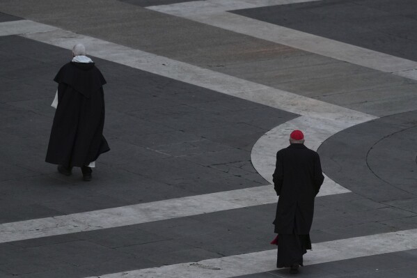 Cardinal Mauro Gambetti, right, walks away after leading a rosary prayer for the late Pope Francis, in St. Peter's Square at the Vatican, Monday April 21, 2025. (AP Photo/Andrew Medichini)