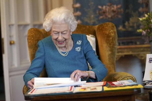 Britain's Queen Elizabeth II looks at a display of memorabilia from her Golden and Platinum Jubilees in the Oak Room at Windsor Castle, Windsor, England, Friday Feb. 4, 2022. Queen Elizabeth II will mark 70 years on the throne Sunday Feb. 6, an unprecedented reign that has made her a symbol of stability as the United Kingdom navigated an age of uncertainty. (Steve Parsons/Pool via AP)