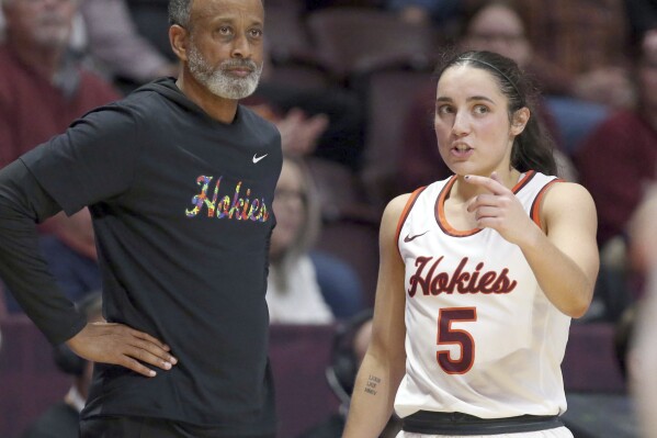 FILE - Virginia Tech head coach Kenny Brooks, left, and Georgia Amoore (5) confer in the first half of an NCAA basketball game against Radford in an NCAA basketball game in Blacksburg Va., Dec. 10, 2023. Brooks earned his 500th career victory on Sunday, Dec. 17, 2023, in a win over Rutgers. His players were wearing shirts after the game in honor of their coach, who last year guided the team to its first-ever Final Four. (Matt Gentry/The Roanoke Times via AP, File)
