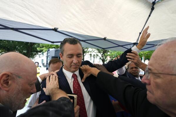 FILE - In this June 7, 2021 file photo, Tony Spell, pastor of the Life Tabernacle Church of Central City, La., prays with supporters outside the Fifth Circuit Court of Appeals in New Orleans.  Health officials have an unsteady partner as they try to get more people vaccinated against COVID-19 in the Bible Belt: churches and pastors. Some preachers are praying for more inoculations and hosting vaccination clinics. Others are skirting the topic of vaccines or openly preaching against them in a region that's both deeply religious and reeling from a spike in cases. (AP Photo/Gerald Herbert)