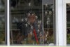Policiais com janelas danificadas trabalham no local de um tiroteio no supermercado Mad Butcher em Fordyce, Arkansas, sexta-feira, 21 de junho de 2024.  (Colin Murphy/Arkansas Democrat-Gazette via AP)