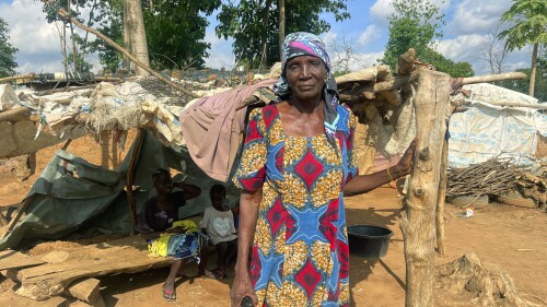 Rifkatu Andruwus, 66, stands in front of her makeshift home, at the Durami camp for the displaced, in Abuja, Nigeria, Friday, June 9, 2023. Hundreds remain homeless in Nigeria's capital of Abuja after losing their shanties to government bulldozers. Authorities say the demolitions seek to rid the city of crime and restore Abuja's master plan, a conceptual layout meant to promote growth of this oil-rich Western African nation. (AP Photo/Chinedu Asadu)