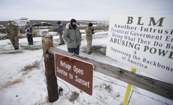FILE - In this Monday, Jan. 4, 2016, file photo, members of the group occupying the Malheur National Wildlife Refuge headquarters stand guard near Burns, Ore. When armed protesters took over a remote wildlife refuge in eastern Oregon to oppose federal control of public lands, U.S. agents negotiated with the conservative occupiers for weeks while some state leaders begged for stronger action. In July 2020, federal officers sent to Portland, Ore., to quell chaotic protests against racial injustice took swift and, some say, harsh action: launching tear gas, firing less-lethal ammunition and helping arrest more than 40 people in the first two weeks. (AP Photo/Rick Bowmer, File)