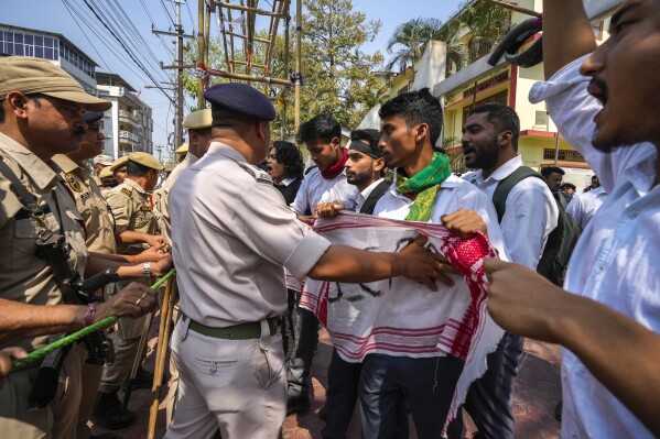 Police stop students trying to protest against the Citizenship Amendment Act (CAA) in Guwahati, India, Tuesday, March 12, 2024. India implemented a controversial citizenship law that was widely criticized for excluding Muslims, a minority community, whose concerns have intensified under the Hindu nationalist government of Prime Minister Narendra Modi.  The act provides fast-track naturalization for Hindus, Parsis, Sikhs, Buddhists, Jains and Christians who fled to Hindu-majority India from Afghanistan, Bangladesh and Pakistan before December 31, 2014. (AP Photo/Anupam Nath)