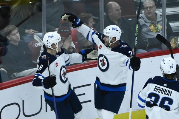 Winnipeg Jets right wing Saku Maenalanen (8) celebrates with center Dominic Toninato after Maenalanen scored a goal against the Chicago Blackhawks during the second period of an NHL hockey game, Sunday, Nov. 27, 2022, in Chicago. (AP Photo/Matt Marton)