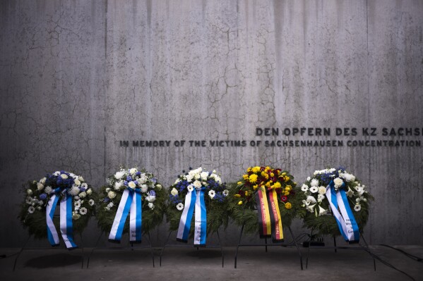 FILE - Wreaths at the memorial wall of the Nazi concentration camp Sachsenhausen after a ceremony marking the Holocaust Martyrs' and Heroes' Remembrance Day in Oranienburg, Germany, Tuesday, April 18, 2023. German prosecutors say a 98-year-old man has been charged with being an accessory to murder as a guard at the Nazis’ Sachsenhausen concentration camp between 1943 and 1945. Nazis’ Sachsenhausen concentration camp between 1943 and 1945. (AP Photo/Markus Schreiber, File)