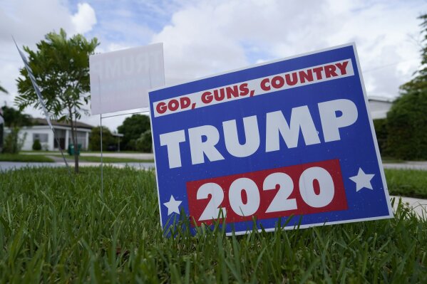 A campaign sign in support of President Donald Trump sits on a lawn Thursday, Oct. 22, 2020, in a Hispanic neighborhood of Miami. Florida's Cuban American voters remain a bright spot in Trump's effort to retain his winning coalition from 2016. Polls show his strong support from these key voters may even be growing to include the younger Cuban Americans that Democrats once considered their best hope of breaking the GOP's hold. (AP Photo/Lynne Sladky)