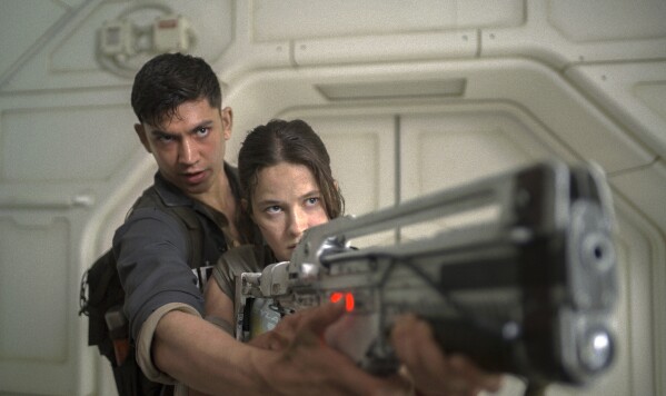 This image released by 20th Century Studios shows Archie Renaux, left, and Cailee Spaeny in a scene from "Alien: Romulus." (20th Century Studios via AP)