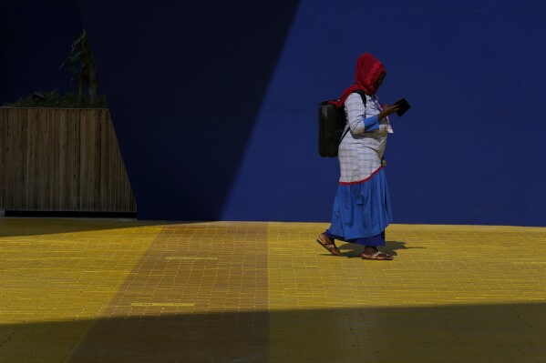 A woman walks through the COP28 U.N. Climate Summit, Dec. 5, 2023, in Dubai, United Arab Emirates. (AP Photo/Peter Dejong)