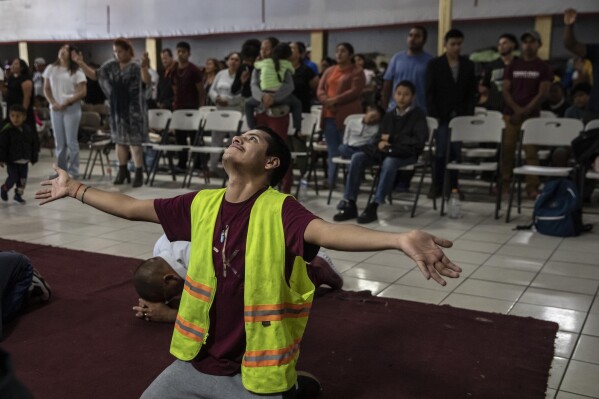 A Mexican migrant prays during a service at the "Embajadores de Jesus" Christian migrant shelter in Tijuana, Mexico, Tuesday, Sept. 26, 2023. While many places in Mexico provide shelter for migrants from other countries, some shelters in Tijuana have seen an influx of Mexicans fleeing violence, extortion and threats by organized crime. (AP Photo/Karen Castaneda)