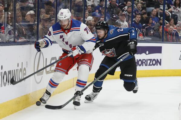 New York Rangers' Jonny Brodzinski, left, and Columbus Blue Jackets' Andrew Peeke chase the puck during the first period of an NHL hockey game on Monday, Jan. 16, 2023, in Columbus, Ohio. (AP Photo/Jay LaPrete)