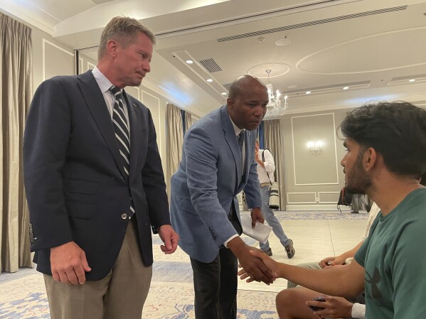 UNC-Chapel Hill Chancellor Kevin Guskiewicz, left, and UNC Chief of Police Brian James console students who had spent hours on lockdown during an active shooter situation on campus, Monday, Aug. 28, 2023, in Chapel Hill, N.C. (AP Photo/Hannah Schoenbaum)