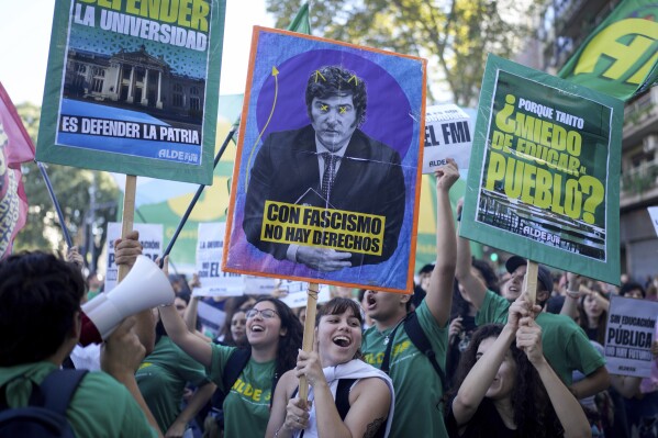 Los estudiantes protestan por más financiamiento para las universidades públicas y contra las medidas de austeridad propuestas por el presidente Javier Miley, que aparece en la pancarta, en Buenos Aires, Argentina, el martes 23 de abril de 2024. Los carteles están escritos en español "Con el fascismo no hay derechos" Centro, y "¿Por qué todo este miedo a educar a la gente?" Derecha y "Defender la universidad es defender la patria" Dejar.  (Foto AP/Natasha Pisarenko)