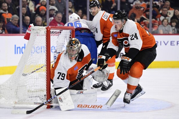 Philadelphia Flyers' goaltender Carter Hart (79) looks for a loose puck as Nick Seeler (24) defends during the first period of an NHL hockey game against the Colorado Avalanche, Saturday, Jan. 20, 2024, in Philadelphia. (AP Photo/Derik Hamilton)