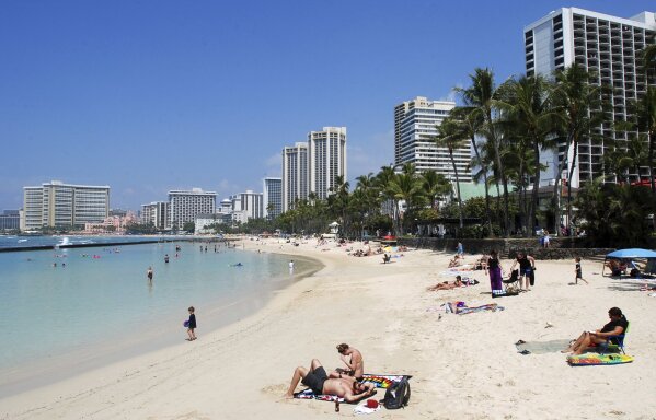 
              FILE - In this Monday, March 13, 2017 file photo, people relax on the beach in Waikiki in Honolulu. A federal judge in Hawaii is hearing arguments on whether to extend his temporary order blocking President Donald Trump’s revised travel ban. A hearing in Honolulu is set for Wednesday, March 29, 2017.  (AP Photo/Caleb Jones, File)
            
