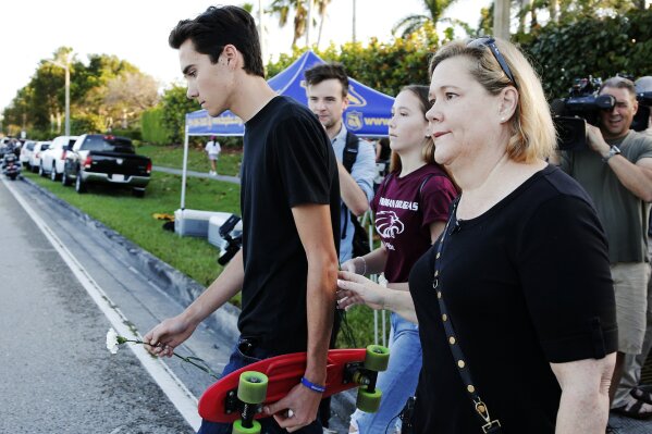 
              Marjory Stoneman Douglas High School student David Hogg, left, walks to class for the first time since a former student opened fire there with an assault weapon, Wednesday, Feb. 28, 2018, in Parkland, Fla. "This is a picture of education in fear in this country. The NRA wants more people just like this, with that exact firearm to scare more people and sell more guns," said Hogg, who has become a leading voice in the students' movement to control assault weapons .(AP Photo/Terry Renna)
            
