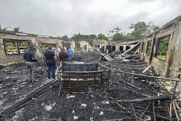 FILE - This photo provided by Guyana's Department of Public Information shows the charred remains of a dormitory at a high school for Indigenous girls after an overnight fire in Mahdia, Guyana, May 22, 2023. The parents of two teenagers who survived the fire that killed 20 people have sued the government for negligence, according to documents attorneys shared with reporters late Feb. 21, 2024. (Guyana's Department of Public Information via APPhoto, File)