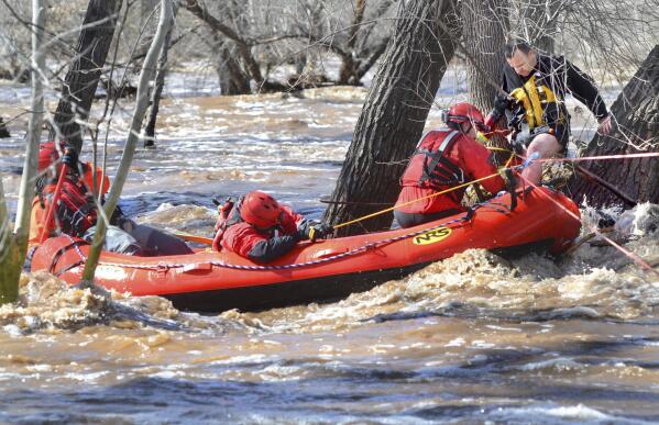 A man stuck in a tree is rescued by swift water teams from Copper Canyon Fire and Medical District, and the Verde Valley Fire District on Wednesday, March 22, 2023, in Camp Verde, Ariz. Several water rescues were reported across central and northern Arizona on Wednesday. (Vyto Starinskas/The Daily Courier via AP)