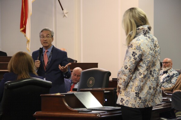 Sen. Michael Lee, a New Hanover County Republican, addresses a series of questions from Democratic Sen. Mary Wills Bode regarding the funding expansion of the Opportunity Scholarship program on the Legislative Building's Senate floor in Raleigh, N.C. on Thursday, May 2, 2024. The Senate approved a measure to soon spend hundreds of millions of dollars more on the program, which allows children to receive taxpayer-funded scholarships to attend K-12 private or religious schools. (AP Photo/Makiya Seminera)