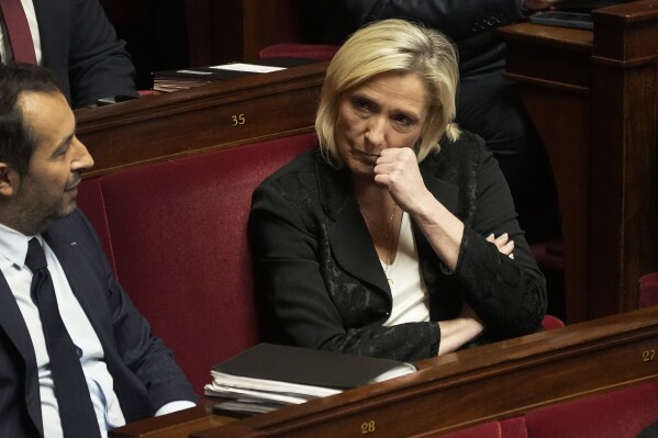 French far-right leader Marine Le Pen listens as French Interior Minister Gerald Darmanin delivers a speech at the French National Assembly in Paris, Monday, dec. 11, 2023. A divisive migration bill that would speed up deportations reaches the lower house of French parliament. (AP Photo/Michel Euler)