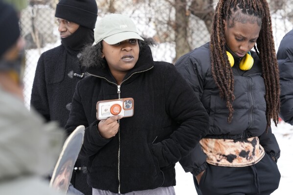Jamilyha Lowery, center, talks to family and friends gathered at the grave of her brother, Jameek Lowery, in Garfield, N.J., Thursday, Jan. 18, 2024. Jalea King, right, is Jameek's sister and Ron Jones, left, is his stepfather. (AP Photo/Seth Wenig)