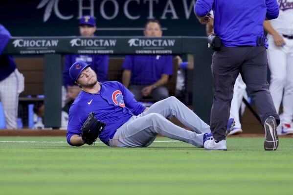 Chicago Cubs starting pitcher Justin Steele falls to the ground, holding his left leg during the fifth inning of the team's baseball game against the Texas Rangers, Thursday, March 28, 2024 in Arlington, Texas. (AP Photo/Gareth Patterson)