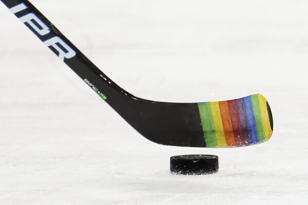 FILE - Zac Jones of the New York Rangers skates with a stick decorated for "Pride Night" in warm-ups prior to the game against the Washington Capitals, May 3, 2021, in New York City. NHL players will be allowed to use Pride tape this season after all. The league, union and a committee on inclusion agreed Tuesday, Oct. 24, 2023, to give players the option to represent social causes with stick tape during warmups, practices and games. (Bruce Bennett/Pool Photo via AP, File)