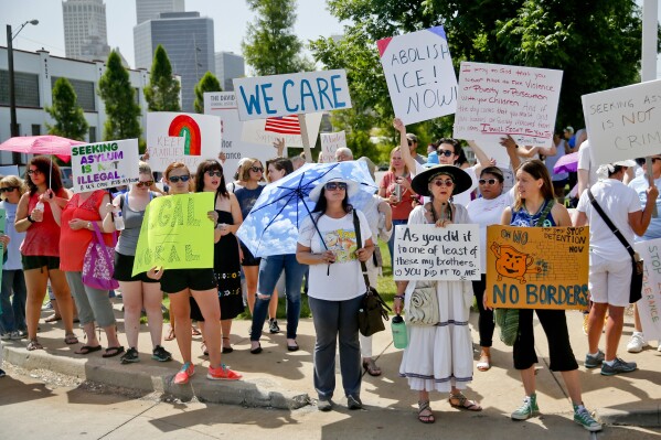 FILE - Marilyn McCulloch and Emily Bickers, both of Tulsa, stand with a group of protestors during a rally against the detaining of immigrant families in front of David L. Moss Criminal Justice Center on Saturday, June 30, 2018, in Tulsa, Okla. (Ian Maule/Tulsa World via AP, File)