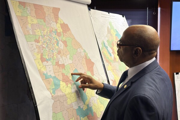 FILE - Georgia Rep. Mack Jackson, D-Sandersville, looks at a map of proposed state House districts before a House hearing, Nov. 29, 2023, at the state Capitol in Atlanta. On Tuesday, Dec. 12, plaintiffs who successfully sued to overturn Georgia's legislative and congressional districts asked a federal judge to reject Georgia's new Republican-backed maps. (AP Photo/Jeff Amy, File)