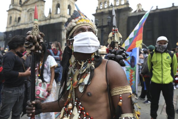 An Indigenous man, wearing a protective face mask, who is participating in a national strike, arrives to Plaza Bolivar in Bogota, Colombia, Wednesday, Oct. 21, 2020. Workers' unions, university students, human rights defenders, and Indigenous communities have gathered for a day of protest in conjunction with a national strike across Colombia. The protest is against the assassinations of social leaders, in defense of the right to protest and to demand advances in health, income and employment. (AP Photo/Fernando Vergara)