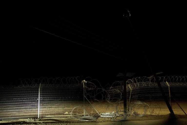 A street lamp shines on a section of the fence that was breached by Hamas on Oct. 7 when they killed or captured a quarter of the residents of Kibbutz Nir Oz, near the Israel-Gaza border, on Nov. 9, 2023. An Associated Press review of Hamas instruction manuals shows the group planned ahead of time to target civilians. (AP Photo/Maya Alleruzzo)