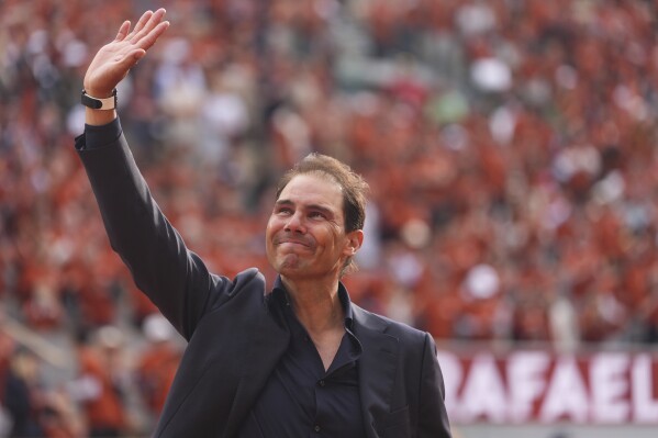 Rafa Nadal waves to the crowd during a farewell ceremony at center court Philippe-Chatrier, at the Roland-Garros stadium, in Paris, Sunday May 25, 2025. (AP Photo/Lindsey Wasson)