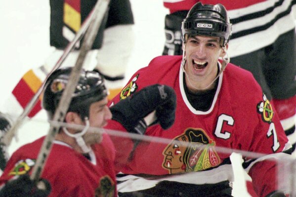 FILE - Chicago Blackhawks captain Chris Chelios, right, congratulates teammate Joe Murphy after Murphy scored the game and series winning goal for the Blackhawks at 10:02 of the third overtime period against the Calgary Flames in Calgary, April 24, 1996. The Blackhawks have decided to retire Hall of Fame defenseman Chris Chelios’ No. 7 jersey. The Blackhawks had Pearl Jam frontman Eddie Vedder deliver the news to his longtime friend during the band’s concert at the United Center on Thursday night, Sept. 7, 2023. (Mike Ridewood/Canadian Press via AP)