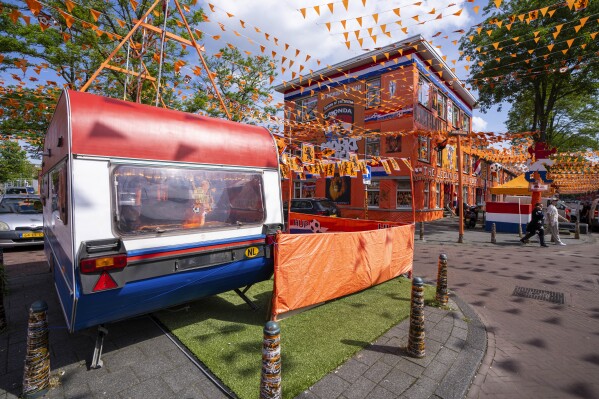 Orange tarp, orange bunting, and Dutch national flags decorate Marktweg street in The Hague, Netherlands, Thursday June 13, 2024, one day ahead of the start of the Euro 2024 Soccer Championship. The Marktweg is one of several streets in the Netherlands that get an all-encompassing orange facelift during European Championships and World Cups when the national team, known as Oranje after the Dutch royal family and the color of their shirts, are playing. (AP Photo/Peter Dejong)
