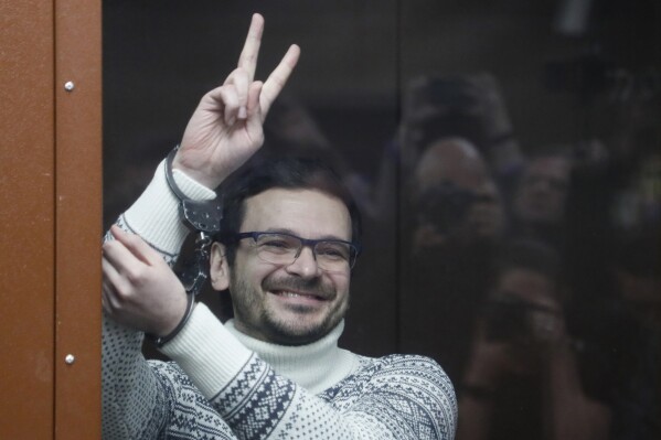 FILE - Ilya Yashin, a Russian opposition activist and former municipal deputy of the Krasnoselsky district, gestures and smiles as he stands in a defendant's cubicle in a courtroom prior to a hearing in Moscow, on Dec. 9, 2022. (Yury Kochetkov/Pool via AP, Pool, File)